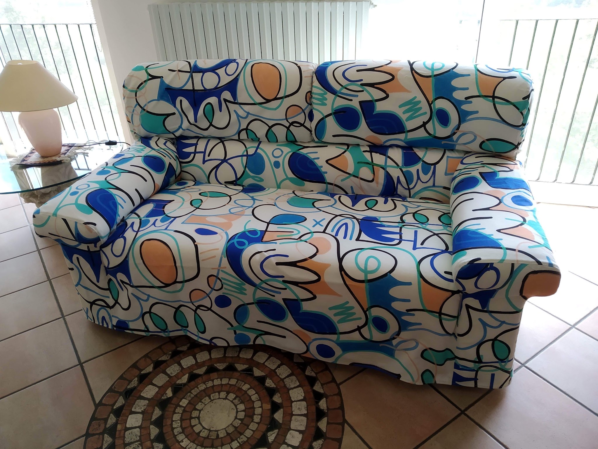 Divano rivestito con tessuto grafico multicolore